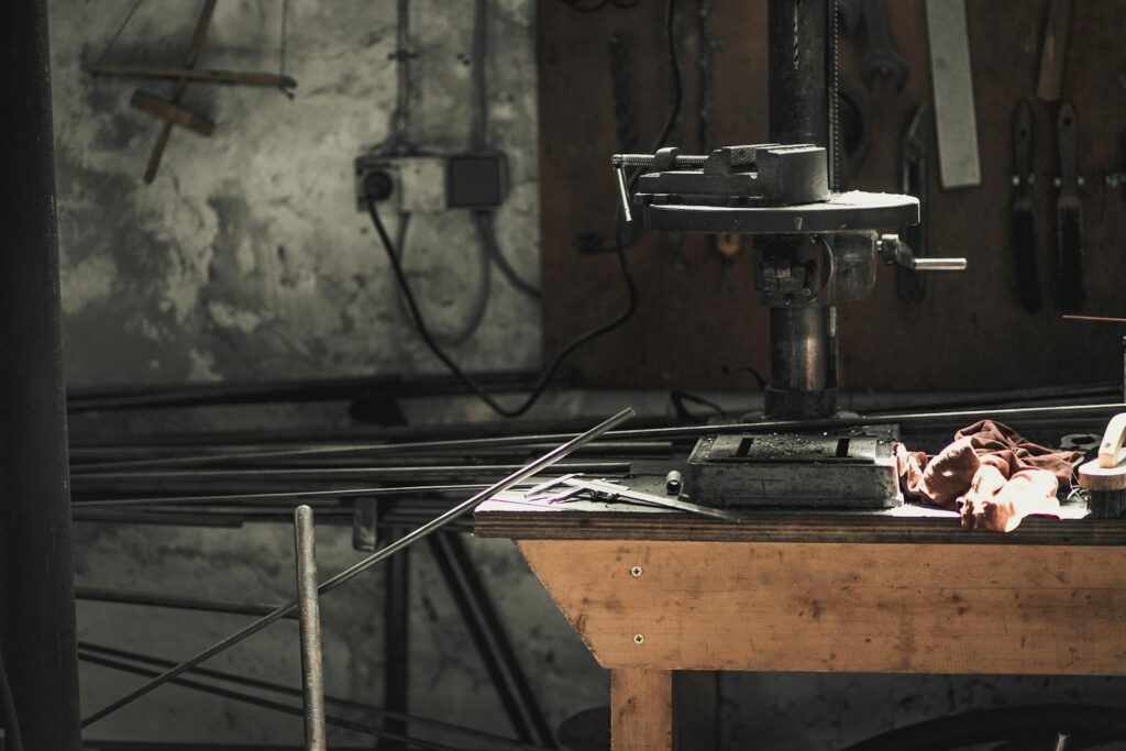 A detailed view of a metalwork workshop showcasing tools, machinery, and steel bars.