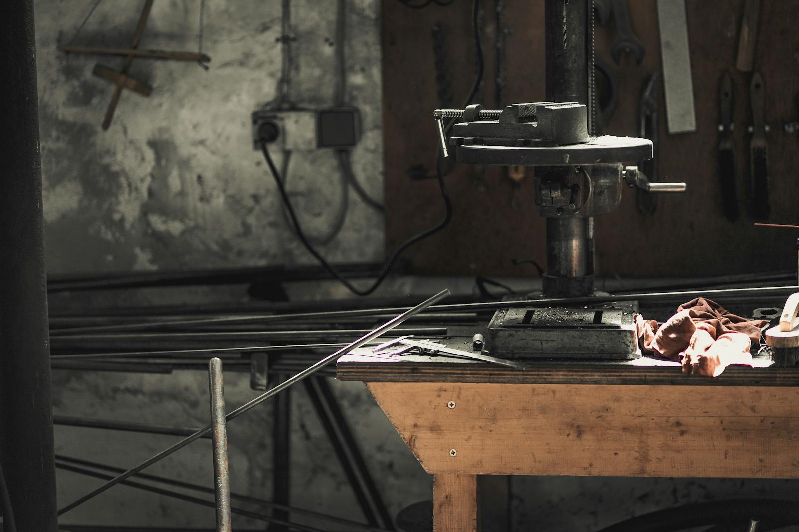 A detailed view of a metalwork workshop showcasing tools, machinery, and steel bars.