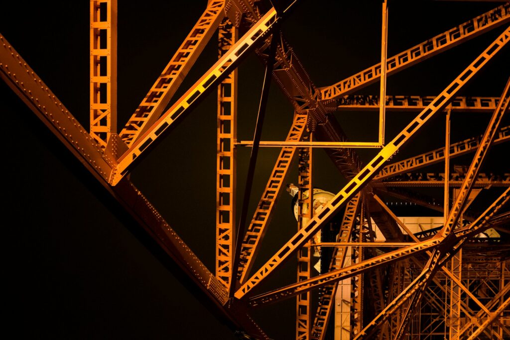Orange illuminated steel girders of Tokyo Tower against a dark night sky